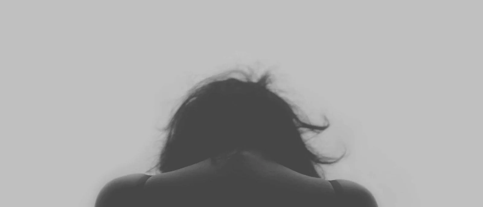 Silhouette einer Frau vor hellem Hintergrund, Gesicht nicht erkennbar