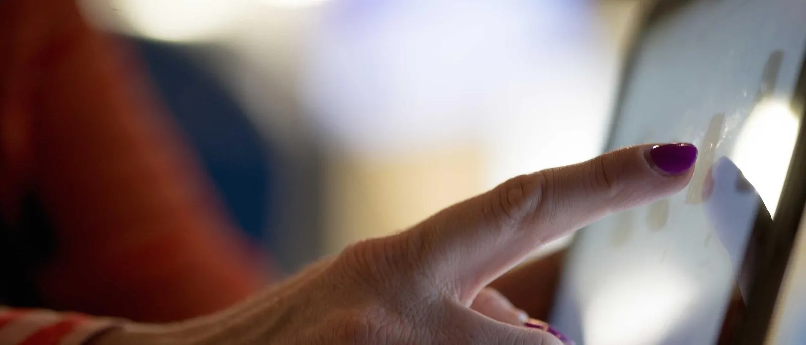 Hand tippt auf ein leuchtendes Smartphone-Display