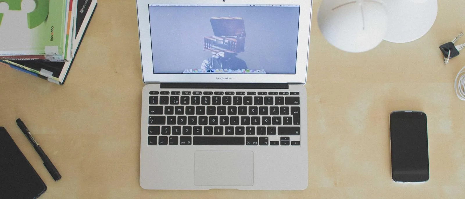 Laptop und Smartphone auf einem hellen Schreibtisch von oben