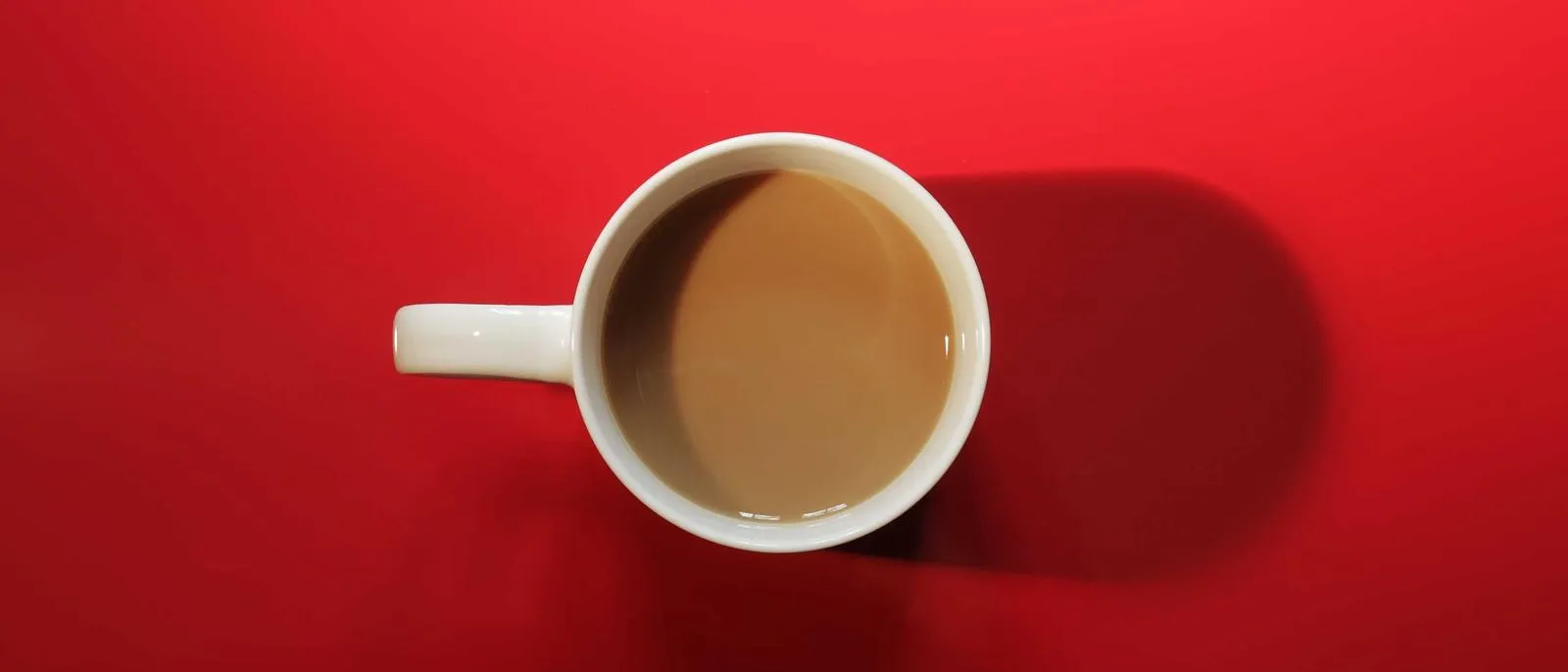 Kaffeetasse auf roter Fläche von oben